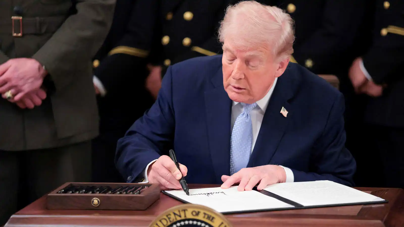 سابقة من نوعها.. ترامب يضع توقيعه على العملة الأمريكية