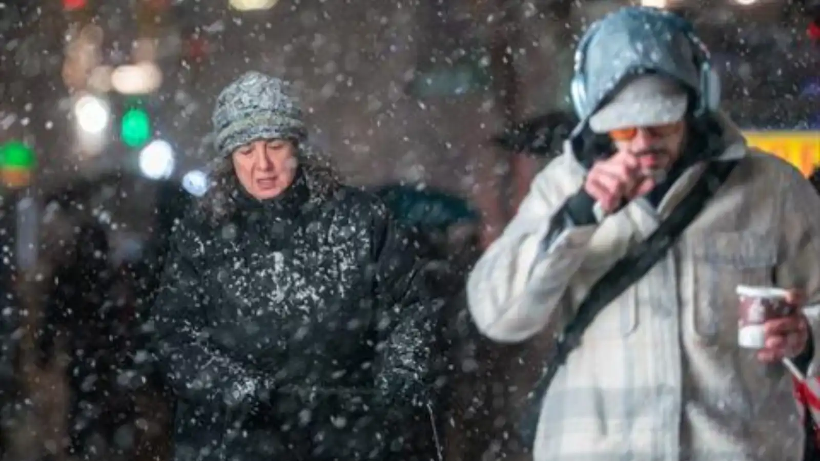 شخصان يسيران في أحد شوارع نيويورك خلال تساقط الثلوج