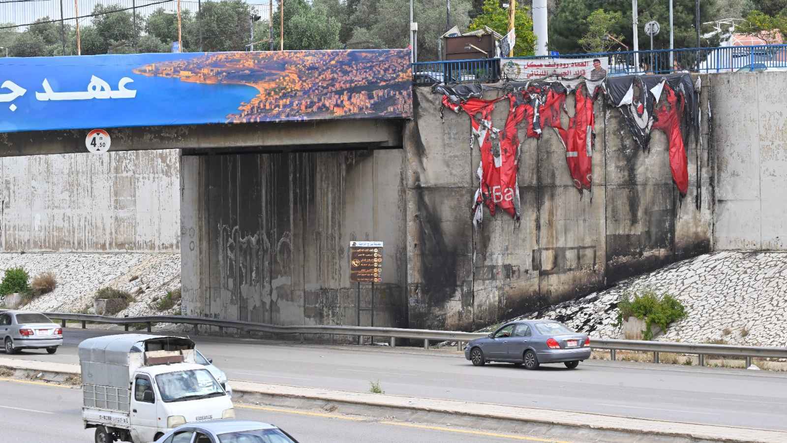 إحراق لافتات "عهد جديد للبنان" على طريق مطار بيروت (صور)