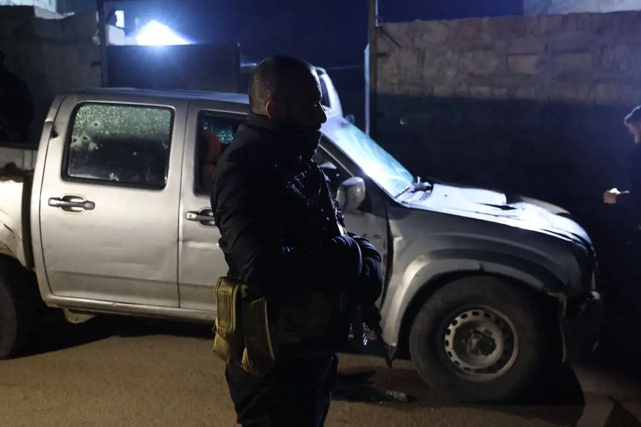 رجل أمن يقف بجانب السيارة، التي تعرضت لإطلاق نار