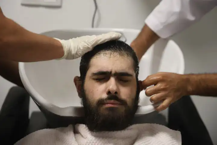 الشاب التركي أثناء قص شعره والاستحمام