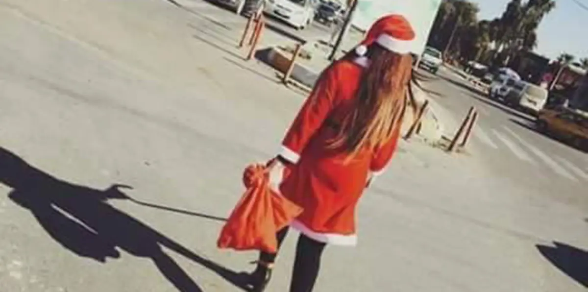 بالصور.. فتاة "سانتا كلوز" تفاجئ القوات الأمنية العراقية بالهدايا