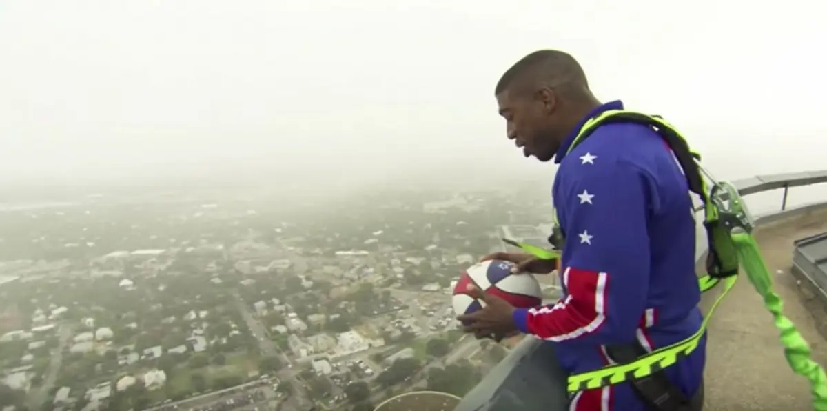 لاعب كرة سلة يحرز هدفًا على الأرض من قمة ناطحة سحاب (فيديو)