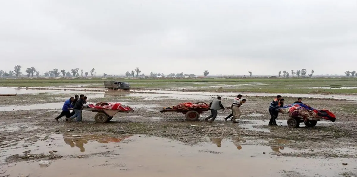 بالصور.. الفارون من معارك الموصل ينقلون معهم الأحياء والأموات