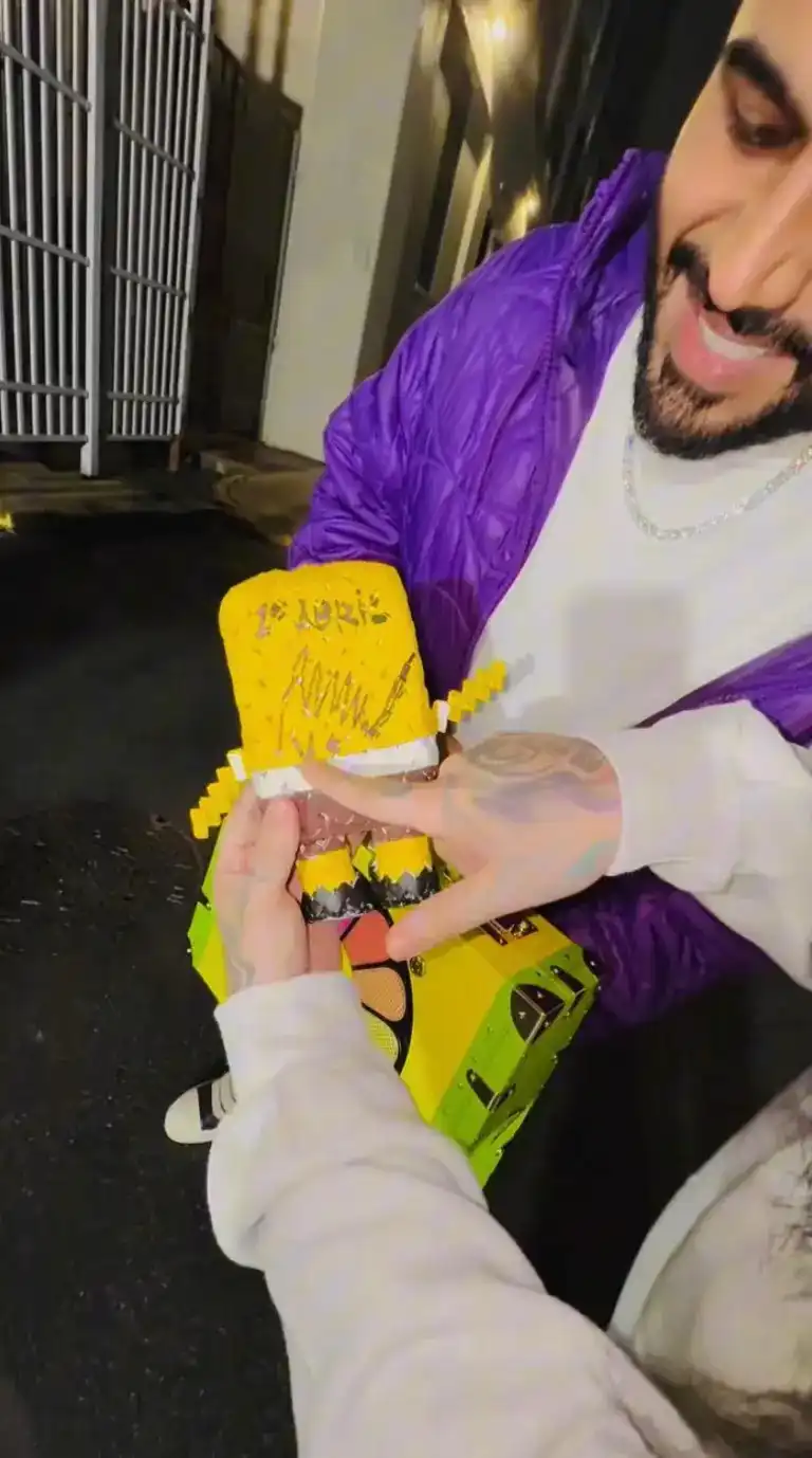 الرابر يستعرض توقيع مادورو على الدمية