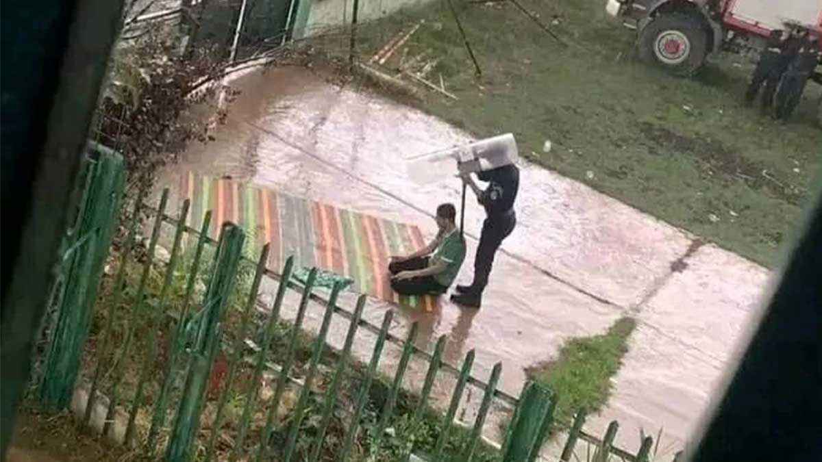 شرطي يحمي مشجعًا من المطر أثناء الصلاة.. صورة تأسر قلوب الجزائريين (فيديو)