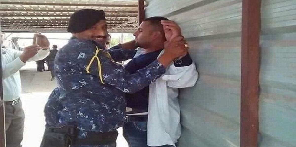 ضابط عراقي يبتسم للكاميرا وهو يقبض على داعشي (صور)