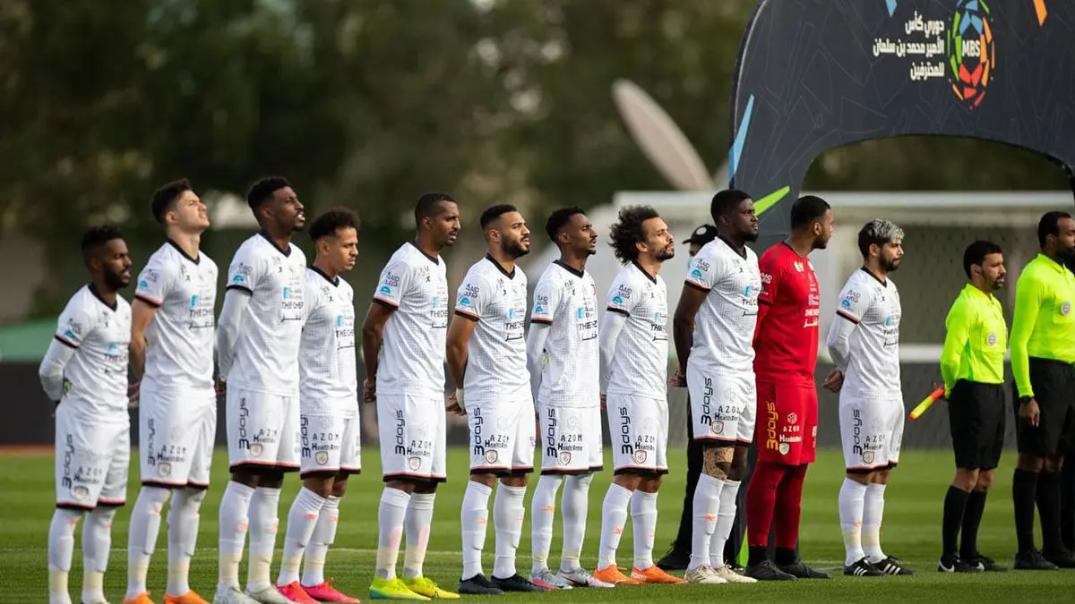 في مشهد غريب.. شخص يخلع كمامته ويمنحها لآخر في مباراة الشباب ضد الباطن (فيديو)