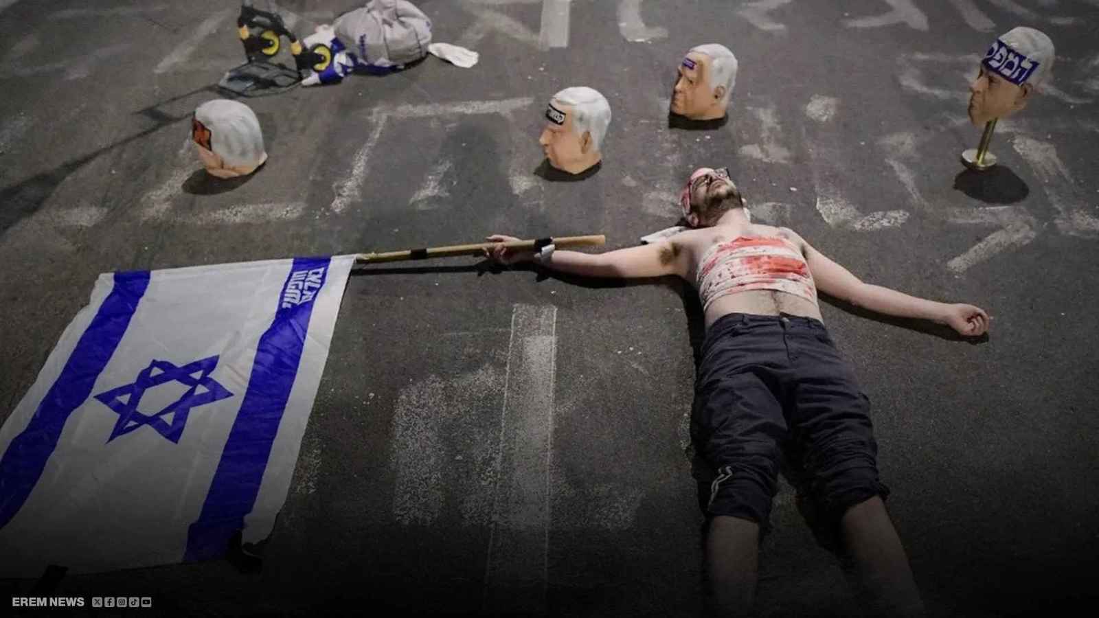 متظاهر إسرائيلي بجانب رؤوس نتنياهو المزيفة