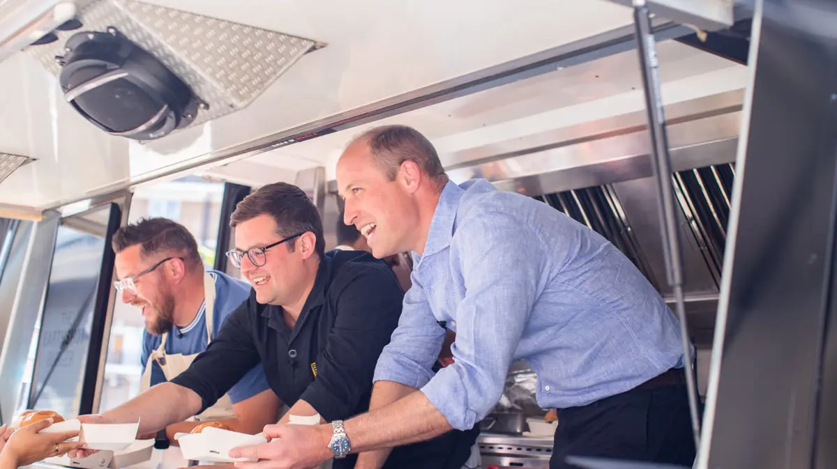 الأمير وليام يقدم الطعام للزبائن على عربة برغر 