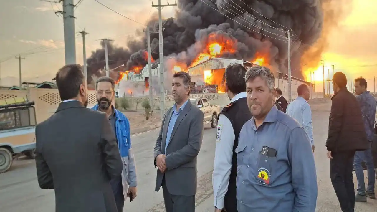 أشخاص يقفون والحريق في الخليفة