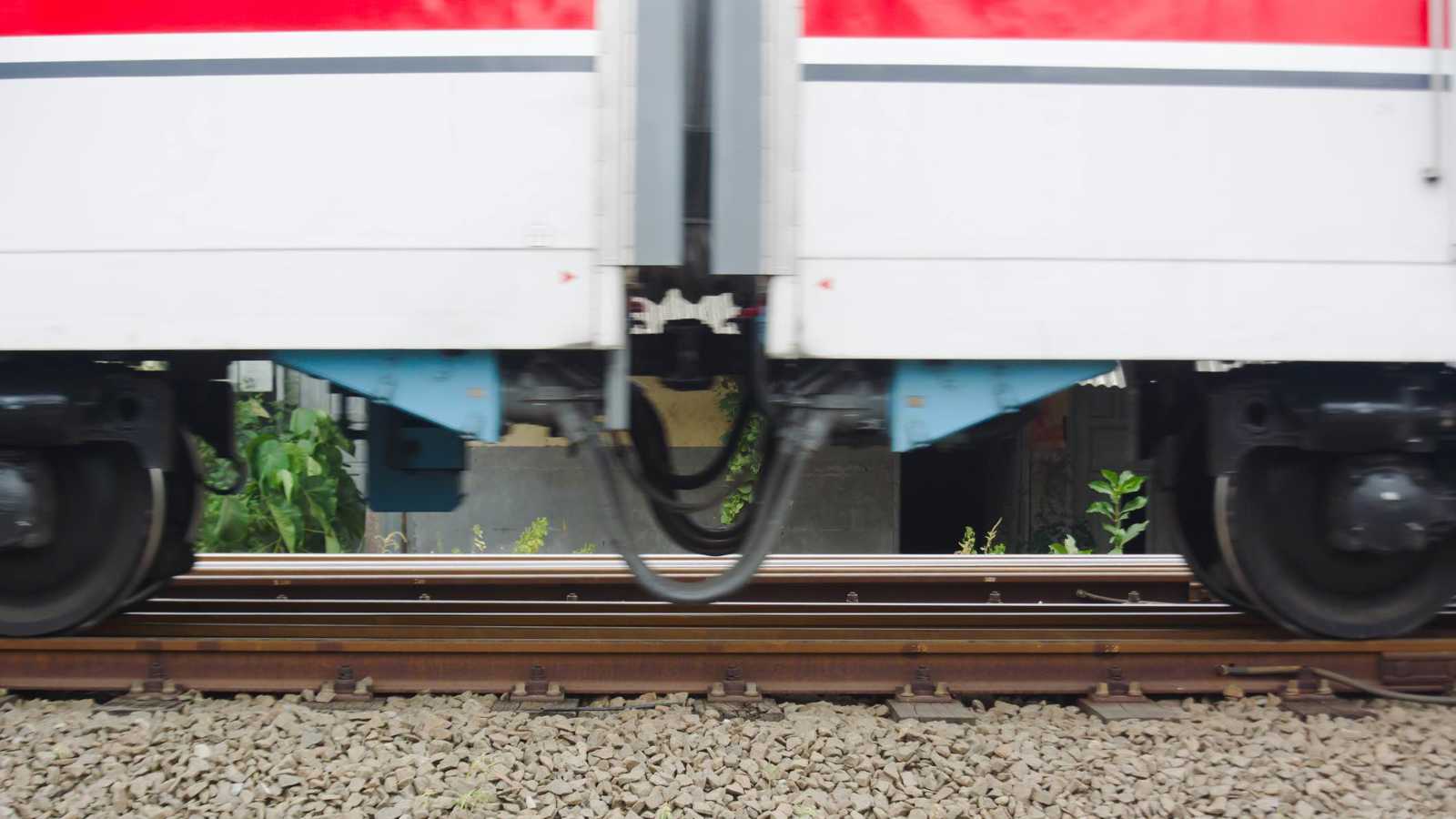 شاب يخاطر بحياته تحت عجلات قطار سريع (فيديو)