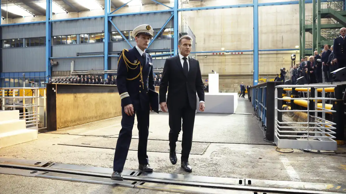 الرئيس الفرنسي إيمانويل ماكرون (يمين) بجانب مسؤول في البحرية الفرنسية بعد إلقاء خطاب بجوار غواصة الصواريخ الباليستية النووية 