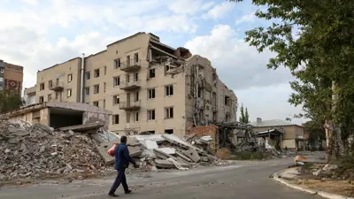 رجل يسير بجوار مبنى تضرر جراء ضربة عسكرية روسية في بوكروفسك