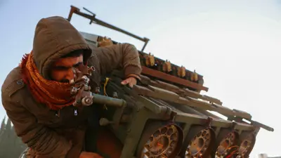 مقاتل من الفصائل المسلحة يعاين قاذفة صواريخ تم الاستيلاء عليها في حلب