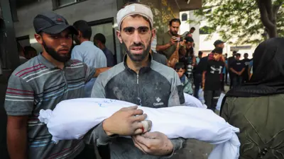 شخص يحمل جثمان طفله في غزة