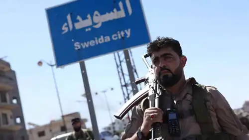 مقاتل سوري أما لافتة لمدينة السويداء