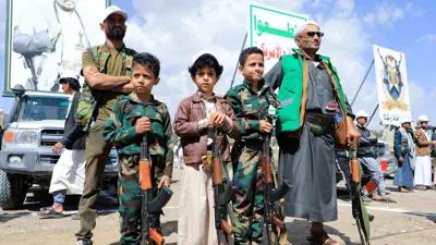 أطفال يمنيون وسط عناصر من ميليشيا الحوثي