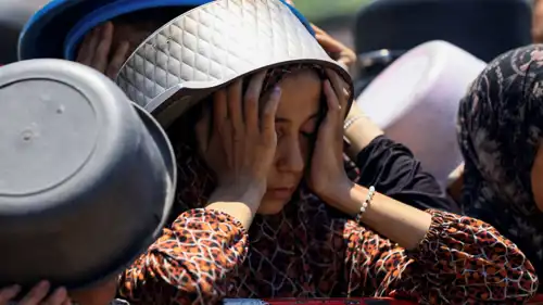 فلسطينية تنتظر مساعدات في غزة