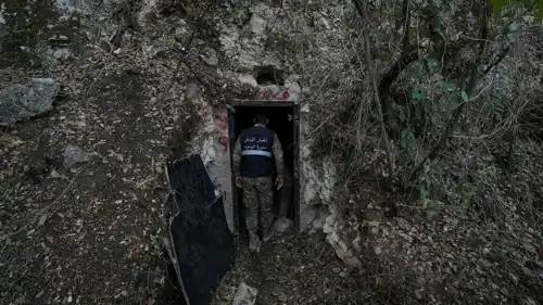 جندي من الجيش اللبناني يقف عند مدخل نفق حُفر في جبل كان