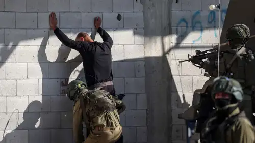 جنود إسرائيليون يفتشون رجلاً فلسطينياً