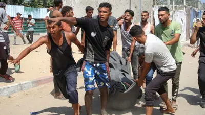 فلسطينيون يحملون إحدى ضحايا القصف الإسرائيلي على خان يونس