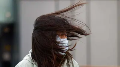 امرأة تمشي وسط رياح قوية في بكين 