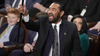 النائب آل غرين رافعا عصاه في الجلسة