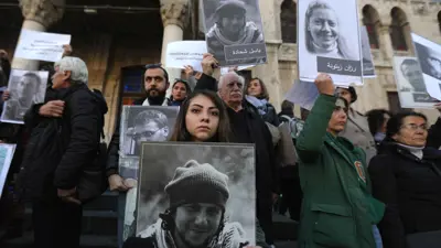  لافتات تحمل صور معتقلين ومفقودين سوريين