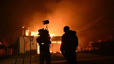 رجلان يقفان أمام الحريق في لوس أنجلوس