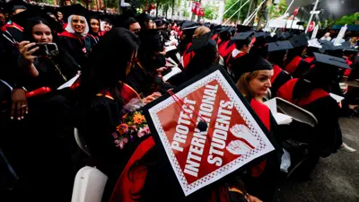 طالب متخرج يرتدي قبعته دعم للطلاب الأجانب في جامعة هارفارد