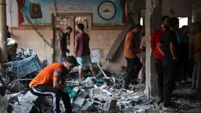 فلسطينيون يجلسون بعد قصف دام على مدرسة التابعين 