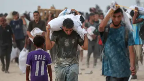  فلسطينيون نازحون يحملون طروداً غذائية في غزة