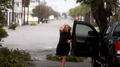 سيدة تهرول نحو سيارتها هربا من العاصفة