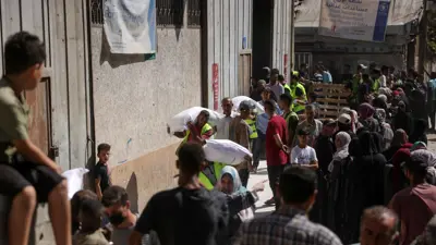 غزيون يحملون أكياس دقيق