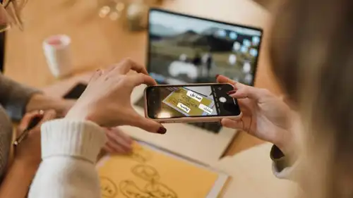 سيدة بيدها الهاتف وتقوم بالتصوير