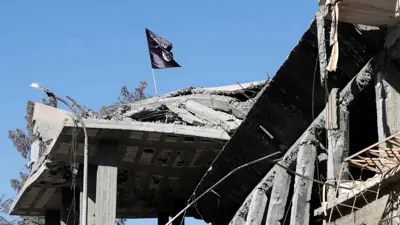 راية تنظيم داعش فوق بناء مهدم - سوريا