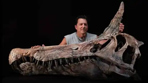 عالم الحفريات بجامعة شيكاغو بول سيرينو يقف إلى جانب جمجمة  "سبينوصوروس ميرابيليس"