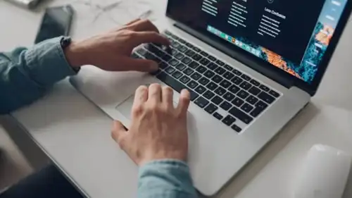 شخص يجلس على جهاز كمبيوتر