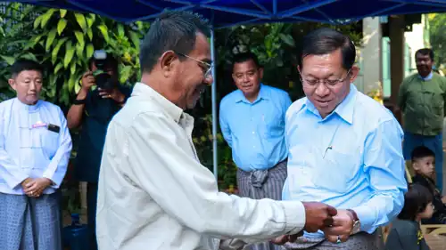 رئيس مجلس ميانمار العسكري مع ناخب خارج مركز اقتراع