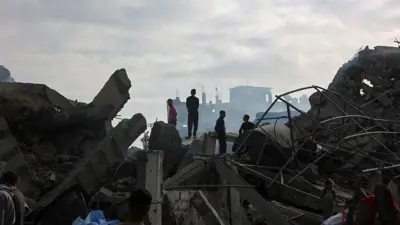 فلسطينيون يقفون على أنقاض منازلهم في غزة