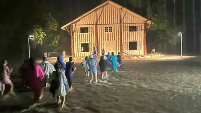 سكان يهربون من السيول تحت الأمطار الغزيرة