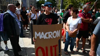 متظاهر يحمل لوحة كتب عليها اخرج يا ماكرون