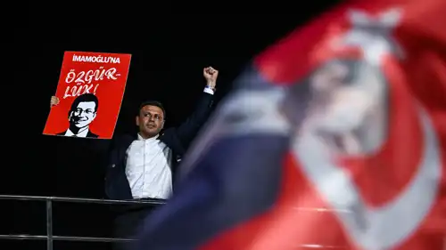 أوزغور جليك يحمل صورة أكرم إمام أوغلو