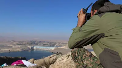 مقاتل من قوات سوريا الديمقراطية ينظر إلى سد تشرين