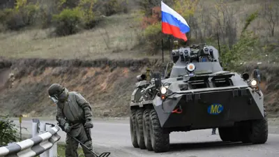 جندي روسي يتفقد محيط مدرعة عسكرية على طريق في أوكرانيا