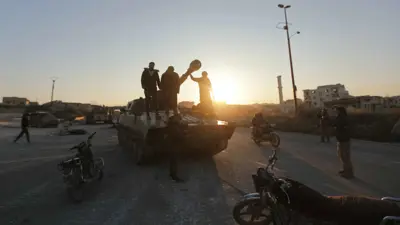 مسلحون يقفون على دبابة في معرة النعمان بإدلب السورية