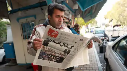 شخص يقرأ نسخة من صحيفة "هم‌ ميهن"