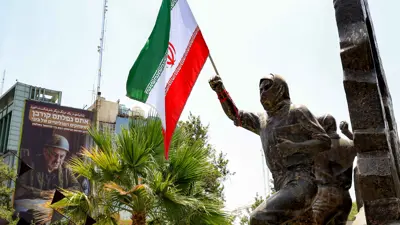 علم إيران مثبت على ذراع تمثال في طهران