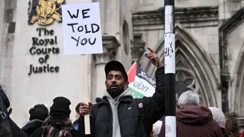 متظاهر مؤيد للفلسطينيين يحمل لافتة أمام المحكمة العليا البريطانية